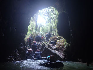 Leading Edge team climbing into a large cave